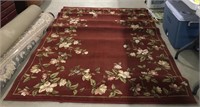 Red flora designed rug measures 88” by 63”