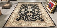 Beige and black rug measures 117” long by 78”