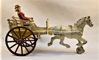 Early 1900's cast iron woman on cart toy 10”
