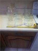 Assorted glass items.  2 large pitchers, one