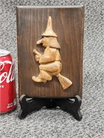 Folkart carved witch in broom mounted on wood