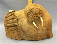 A large fossilized whalebone carving of a walrus w