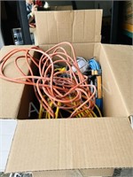 box of various extension cords & trouble light