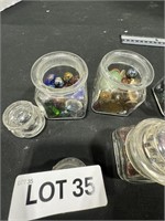 FOUR SMALL CONTAINERS, MARBLES, AND BUTTONS