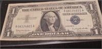 1957 B $1 silver certificate with a protective