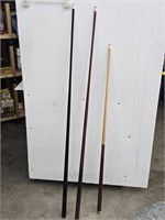 Two titanium pool cues and a short pool cue