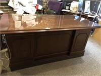 Wooden executive desk w/ glass top on riser