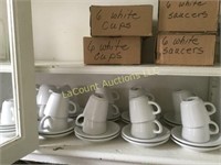 many white coffee cups and saucers some new