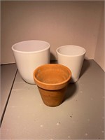 two white ceramic and one terracotta plant pot