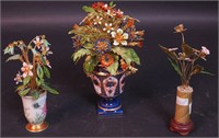 Three small vases, each filled with enameled