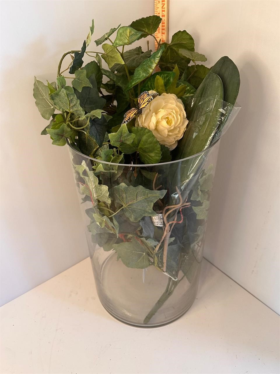 Large glass vase with greenery