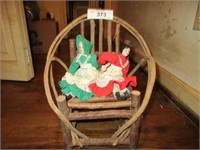 Grapevine chair with 2 old style porcelain dolls