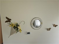 Flowers, mirror and butterfly wall decor seen in