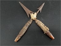 A crossed pair of hand forged arrow heads