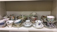 Shelf lot of vintage cups & saucers, most with