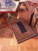 Three manufactured rugs, all red, blue and cream