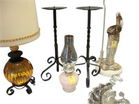 Two iron candle holders, along with an oil lamp