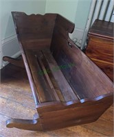 Antique wooden baby cradle with the carved top