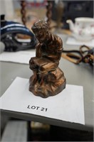 cast metal figure of a young boy in "Thinker" pose