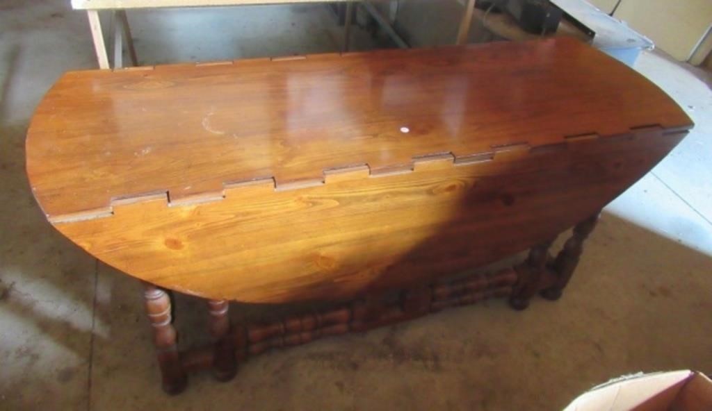 Drop leaf wood table. Measures 66" L x 57" W with