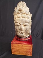 Carved stone buddha head on wooden base