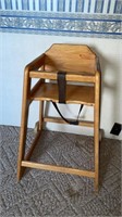 Wooden child's high chair with rear wheels
