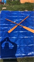 Pair of wooden boat oars and large blue tarp.