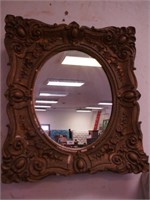 Antique oval wall mirror with heavily decorated