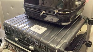 Two traveling hardback suitcases with wheels,