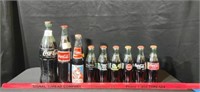 Group of Themed Unopened Coke Bottles 12 total