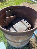 Metal barrel . Over half full of steel plates.