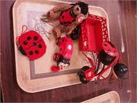 Four ladybug items including wood pull toy,