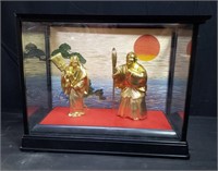 Pair of brass Japanese figurines in a glass case