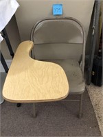 Folding chair with writing area attached