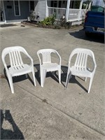 Three plastic lawn chairs