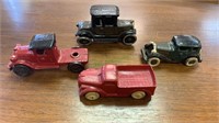 Four antique toy cars, three are cast-iron