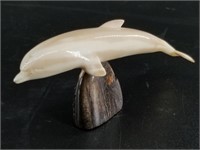 Beautifully carved dolphin from ancient ivory on a