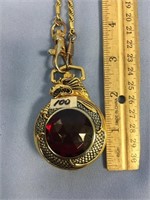 Pocket watch on chain, gold plated with a ruby red