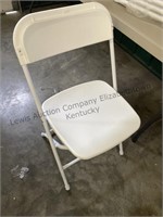 Six white folding chairs