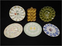 Six deviled egg dishes, several decorated with