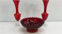 Two stemmed red vases and red candle hold