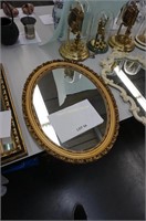 oval plastic mirror with ornate gold frame
