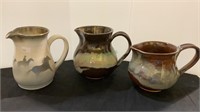 Lot of three glazed pottery pitchers - all
