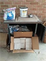 Cabinet with misc tile and partial bags of grout