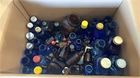 Box lot of vintage blue and amber glass bottles.