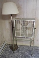 Vintage floor lamp and household fan on stand.