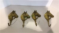 A lot of four brass horse head hooks each