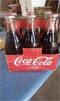 A SIX PACK OF COCA COLA CLASSIC SODA IN CARTON