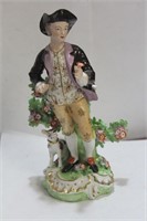 A Porcelain Man with a Dog and Flower Statue