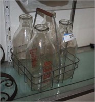 Four Vintage Milk Bottles in Wire Crate